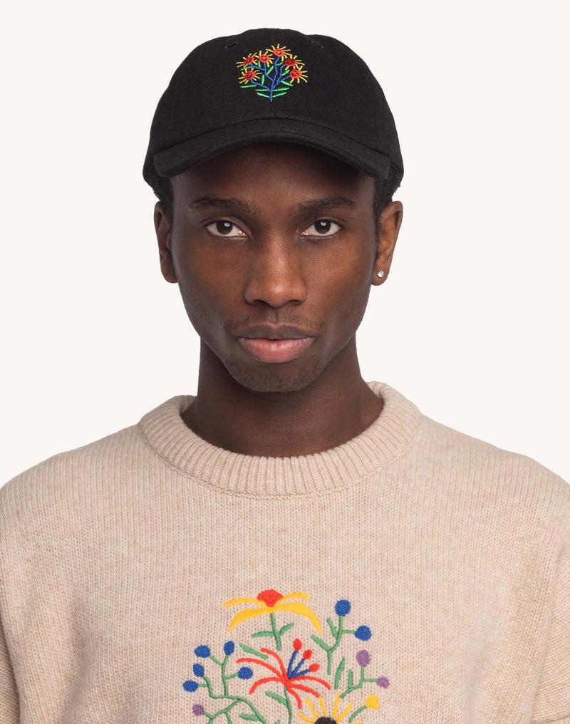 Model trägt die schwarze OLOW Blossom Yourself Cap mit farbiger Blumenstickerei – Vorderansicht